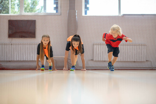 Kids in bright sportswear starting competition - Foto, Bild