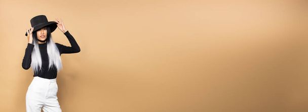 Mode Femme tenir shopping gris Sacs sur fond jaune beige copie espace style bannière, Style de cheveux à la mode asiatique fille avec chapeau noir pantalon blanc - Photo, image