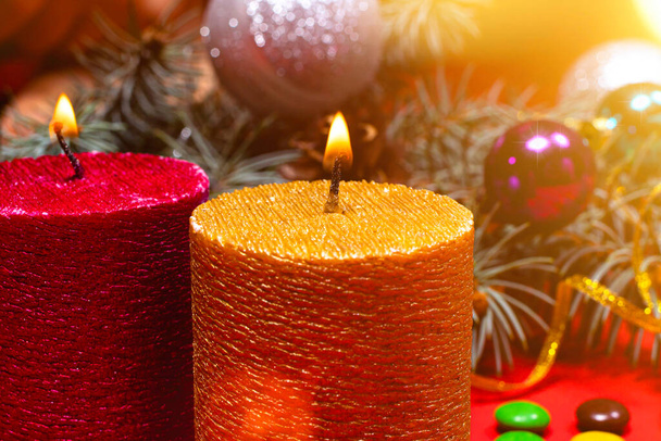 Una bella immagine natalizia - una candela accesa color oro sullo sfondo dell'albero di Natale. Foto romantica vacanza con bokeh - Foto, immagini