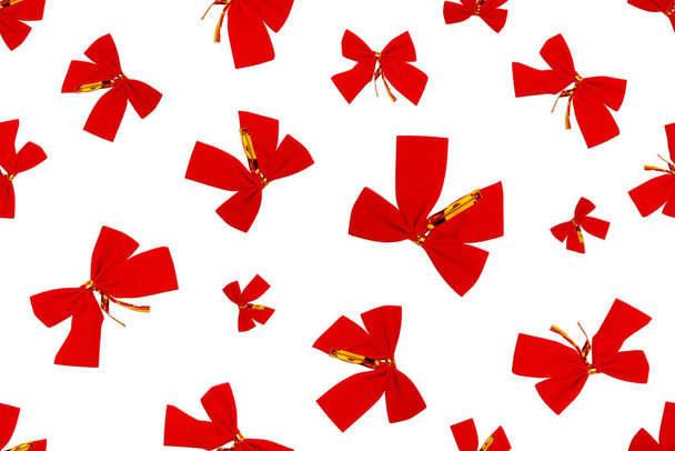 Nahtloses Muster mit roten Schleifen auf weißem Hintergrund. Festlicher Hintergrund, Blick von oben. Weihnachten oder Neujahr Hintergrund. - Foto, Bild