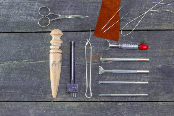 Set plano de kit de herramientas de cuero para principiantes. Juego de instrumentos de cuero sobre fondo de madera. Borde de cuero bruñidor. - Foto, Imagen