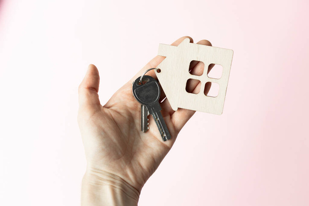 Female hand holding house key,real estate agent. - Foto, afbeelding