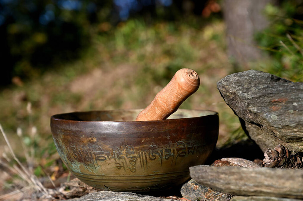 Тибетская поющая чаша на камне. Перевод мантр. преобразовать ваше нечистое тело, речь и ум - Фото, изображение