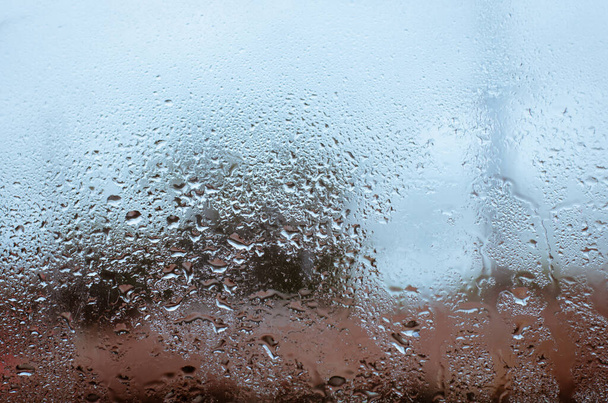 Raindrop Falling Down on the Window Glass for Blurry background. - Фото, изображение
