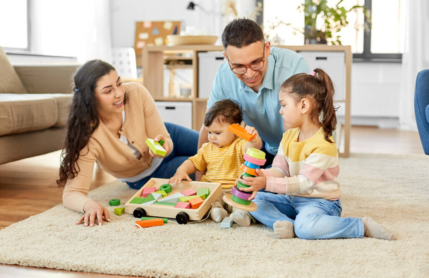 happy family palying with wooden toys at home - Foto, imagen