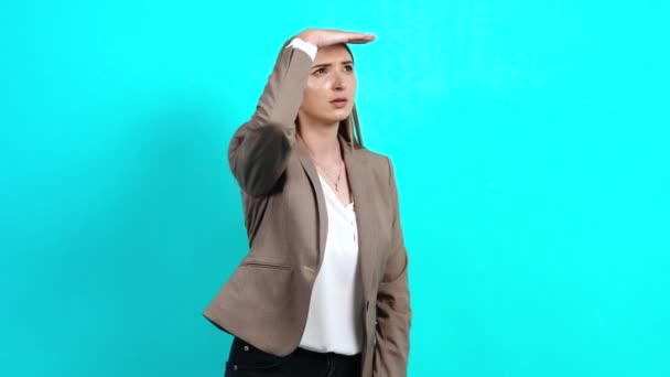 Любопытная молодая женщина, внимательная в деловом костюме, отворачивающаяся, с рукой над головой - Кадры, видео