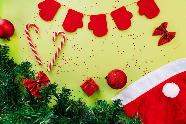 Karácsonyi kívánságlista üdvözlőlap. Karácsonyi kompozíció. Jelen doboz, tűzifa ágak, karácsonyi cukorkák, piros ünnepi dekorációk zöld háttérrel. Másold a helyet. Karácsonyi és újévi ünnepi koncepció - Fotó, kép