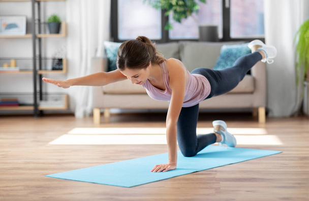 young woman exercising and doing sports at home - Foto, imagen