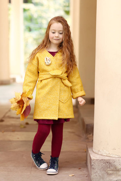 Iers klein rood harig meisje outdoor foto op park architectuur achtergrond - Foto, afbeelding