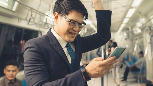 Uomo d'affari che utilizza il telefono cellulare sul treno pubblico - Foto, immagini