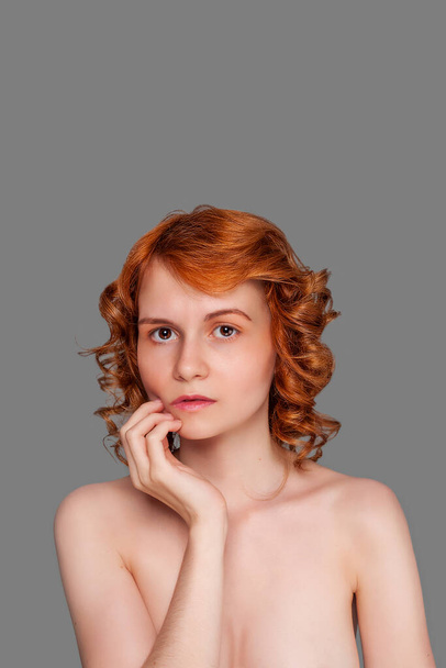 美しい若いです赤毛の女性とともに裸の胸上の灰色の背景 - 写真・画像