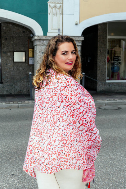 Sorridente giovane donna bionda oversize in abito alla moda per strada. - Foto, immagini