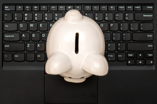 Piggy bank on the black computer keyboard, top view.Make money online or internet business. - Valokuva, kuva