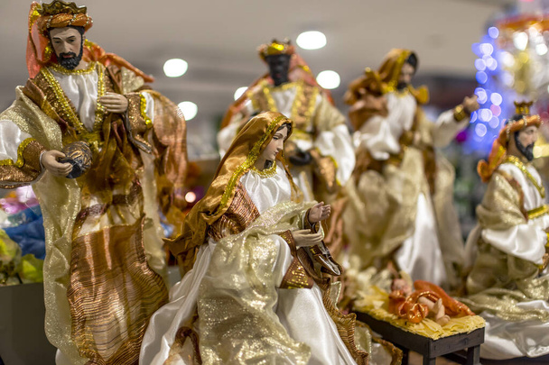 Yksityiskohtaiset miniatyyri luvut kuvaavat Nativity Scene esillä tavaratalo. Joulukoristeet myytävänä. - Valokuva, kuva