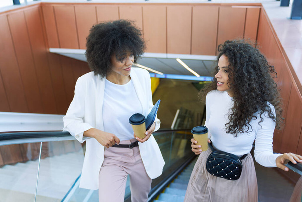 Deux femmes d'affaires monter escalator à l'extérieur                                 - Photo, image