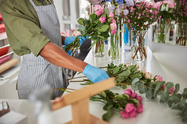 Man making fresh blooming bouquets at florist - 写真・画像