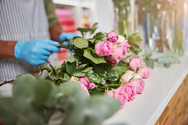 Bloemist met bloeiende rozen tijdens de werkdag - Foto, afbeelding