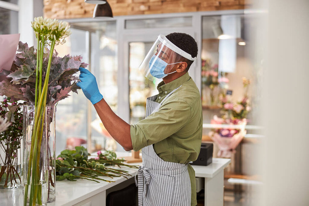 Afro American florist is working in shop - Foto, afbeelding