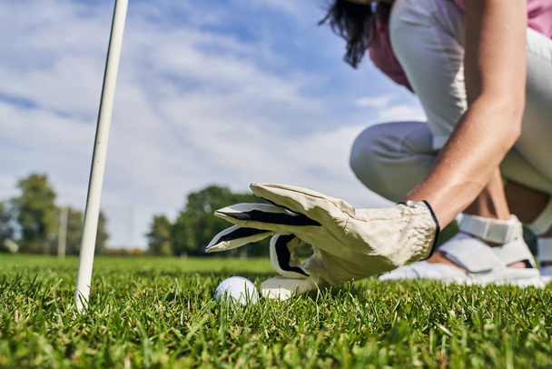 Golfer in a glove sitting on her haunches - Foto, imagen