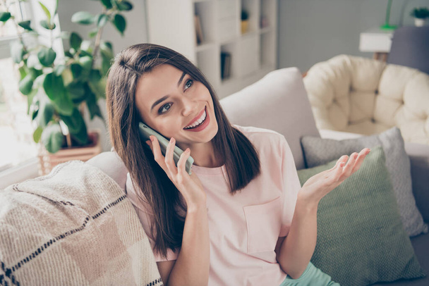Photo portrait of woman talking on the phone sitting on couch indoors - Photo, Image