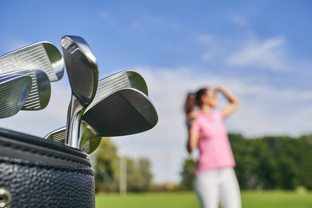 Dark-haired lady golfer on the driving range - Фото, изображение