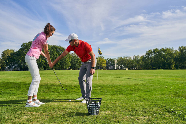 Beginner female golfer learning a proper golf grip - Foto, Bild