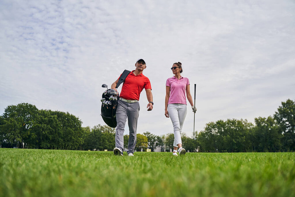 Örömteli női golfozó bámulja a golf oktatóját. - Fotó, kép