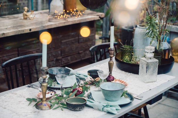 Украшенный стол в рождественской обстановке. Свечи, тарелки и столовые приборы. Высокое качество фото - Фото, изображение