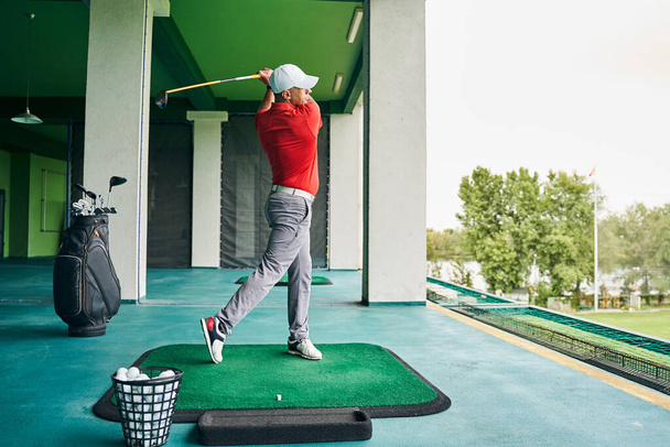 Sportsman swinging his club during the workout - Fotografie, Obrázek