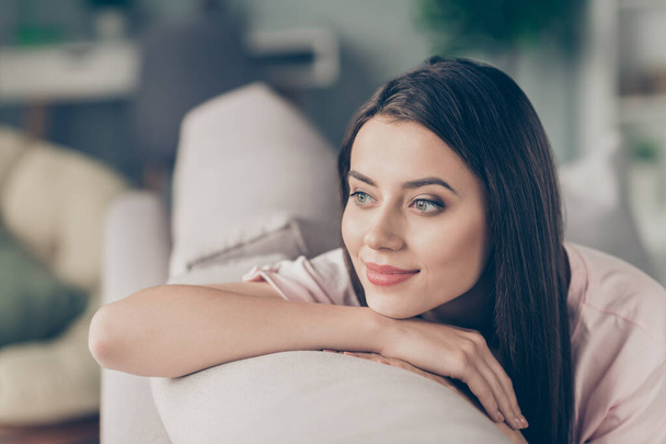 Photo portrait of adorable girl looking into distance thinking lying on hand on sofa indoors - Photo, image