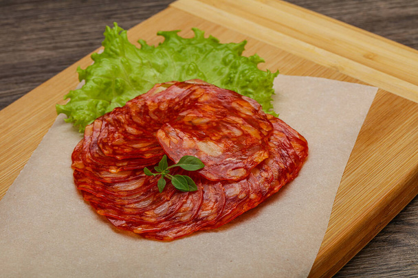 Le tradizionali salsicce di maiale Chorizo servite con foglie di basilico - Foto, immagini