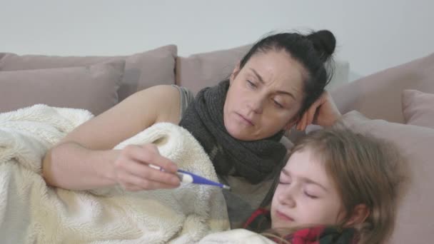 Femme tenant thermomètre près de l'enfant avant de mesurer la température corporelle - Séquence, vidéo