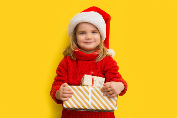 Cute little girl holding gift boxes. - Фото, зображення