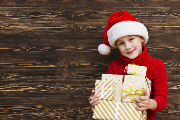 Cute little boy holding gift boxes. - Foto, Imagen