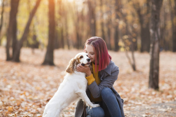 Young woman with her dog in the park. - Foto, afbeelding