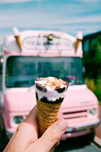 Zmrzlinový kužel s růžovým retro zmrzlinářským náklaďákem nebo dodávkou v pozadí. Kvalitní fotka. Letní vibrace v pastelových barvách.  - Fotografie, Obrázek