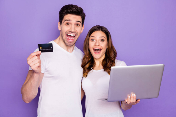 Photo pretty lady handsome guy couple hold notebook spend free time together use plastic wireless credit card online transfer buy delivery food wear t-shirts isolated purple color background - Foto, Bild