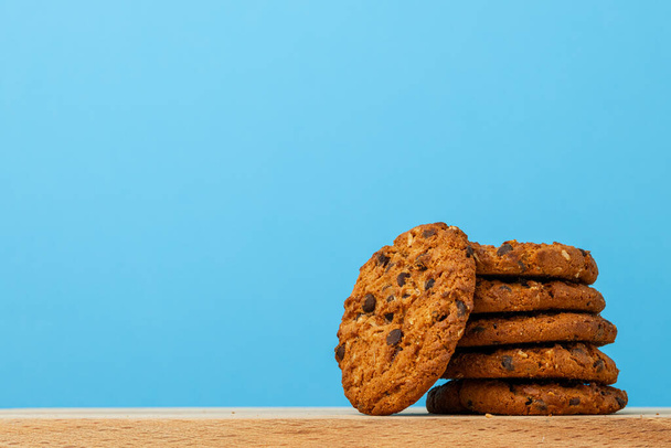 Stack of chocolate chip cookies against blue background - Foto, Imagem