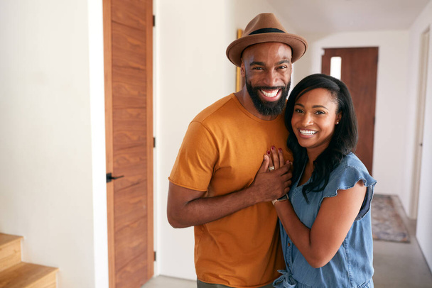 Portrait Of Loving African American Couple Hugging In Hall At Home - Φωτογραφία, εικόνα