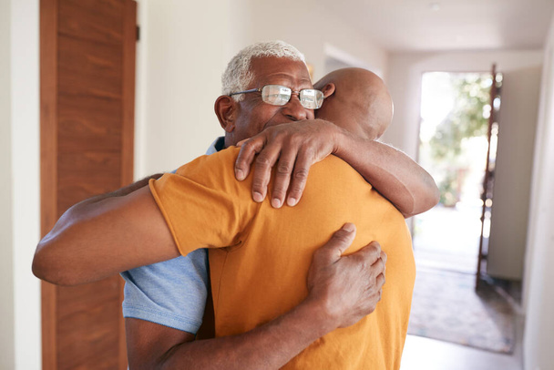 Loving Senior Father Hugging Adult Son Indoors At Home - Foto, Imagen