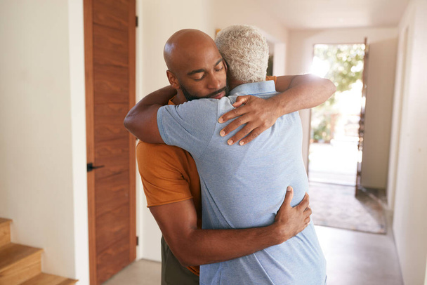 Loving Senior Father Hugging Adult Son Indoors At Home - Foto, imagen