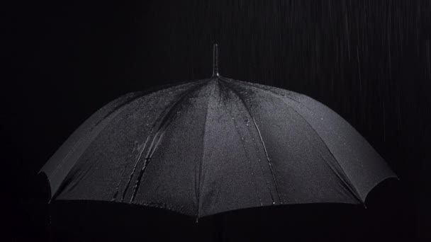 Съемка зонтиков и дождевых капель на черном фоне - Кадры, видео