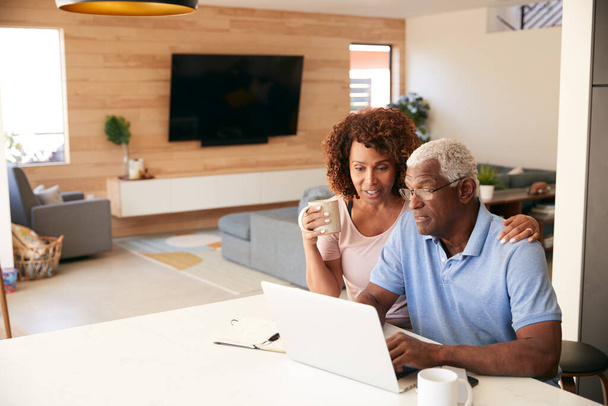 Senior couple afro-américain en utilisant un ordinateur portable pour vérifier les finances à la maison - Photo, image
