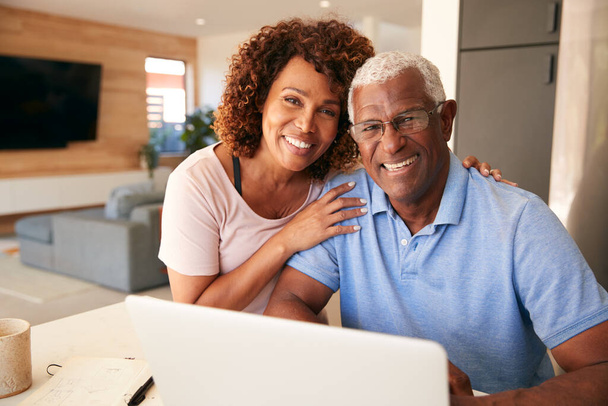 Portrait Of Senior African American Couple Using Laptop To Check Finances At Home - Foto, immagini