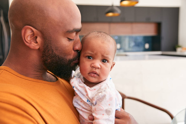 Smiling Stay At Home African American Father Cuddling And Playing With Baby Daughter Indoors At Home - Фото, изображение