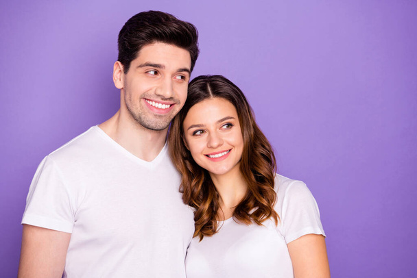 Photo cheerful pretty lady handsome guy couple good mood hugging leaning heads romance look side empty space interested wear casual white t-shirts isolated purple pastel color background - Valokuva, kuva