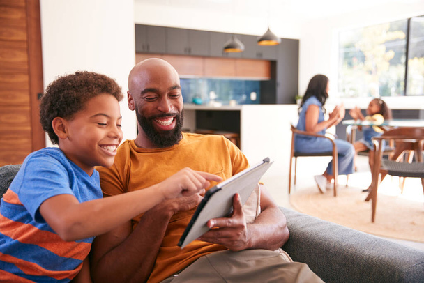 African American Family At Home With Father And Son Sitting On Sofa At Home Using Digital Tablet - Fotografie, Obrázek