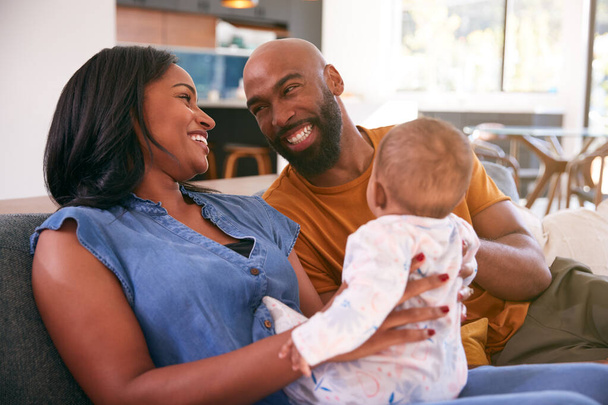 Smiling African American Parents Cuddling And Playing With Baby Daughter Indoors On Sofa At Home - Foto, Bild