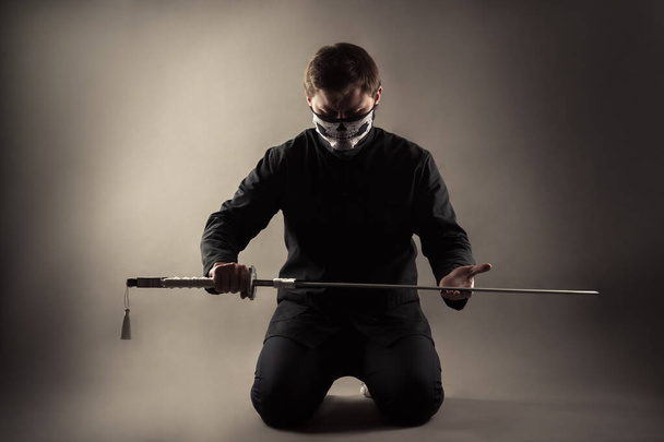 brutal man with katana on knees - Valokuva, kuva