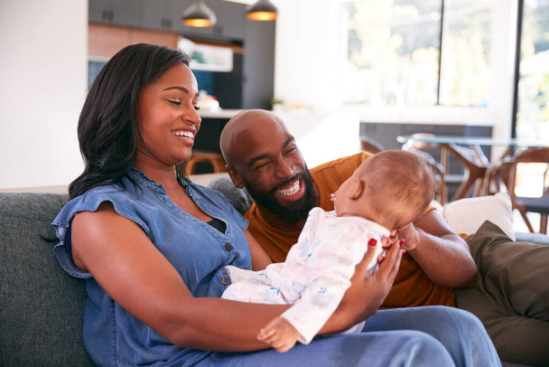 Smiling African American Parents Cuddling And Playing With Baby Daughter Indoors On Sofa At Home - Foto, Imagem